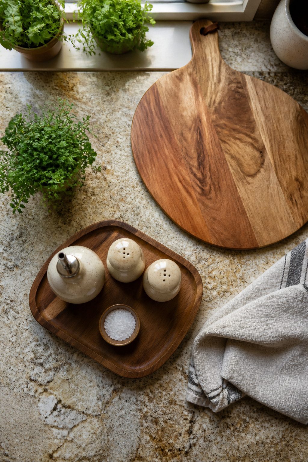 Kitchen countertop with organized tools on a small wood tray.