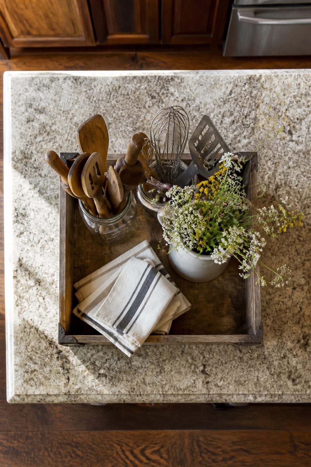 A wooden crate with mason jars, fresh flowers, and cloth napkins.